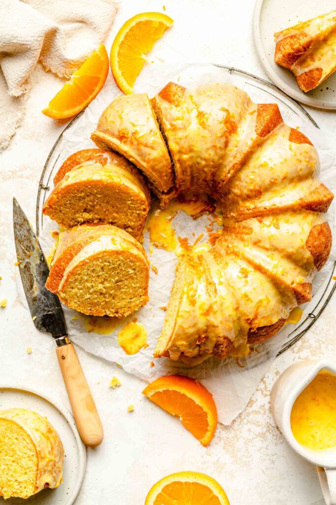 Overhead Image Of Orange Pound Cake With Slices Taken Out Of It.