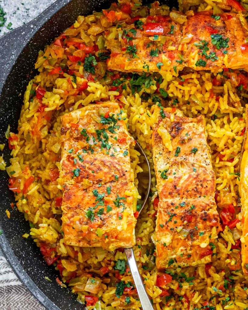 Freshly Made One Pot Salmon And Rice In A Skillet Garnished With Parsley.